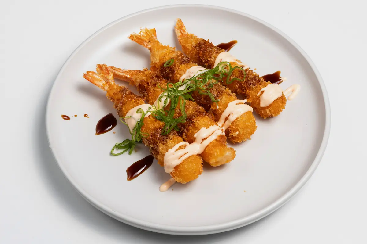 Eby Furay de Amaru Sushi Bar, roll tempurizado relleno de langostino crujiente, aguacate y queso crema, cubierto con salsa especial y presentado en plato elegante